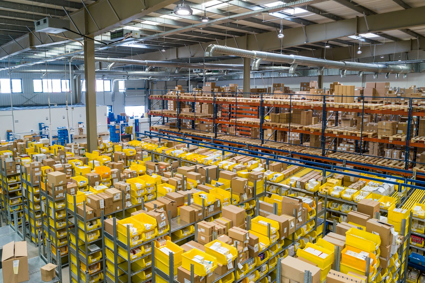 Illustrative warehouse interior with storage racks and a high industrial ceiling